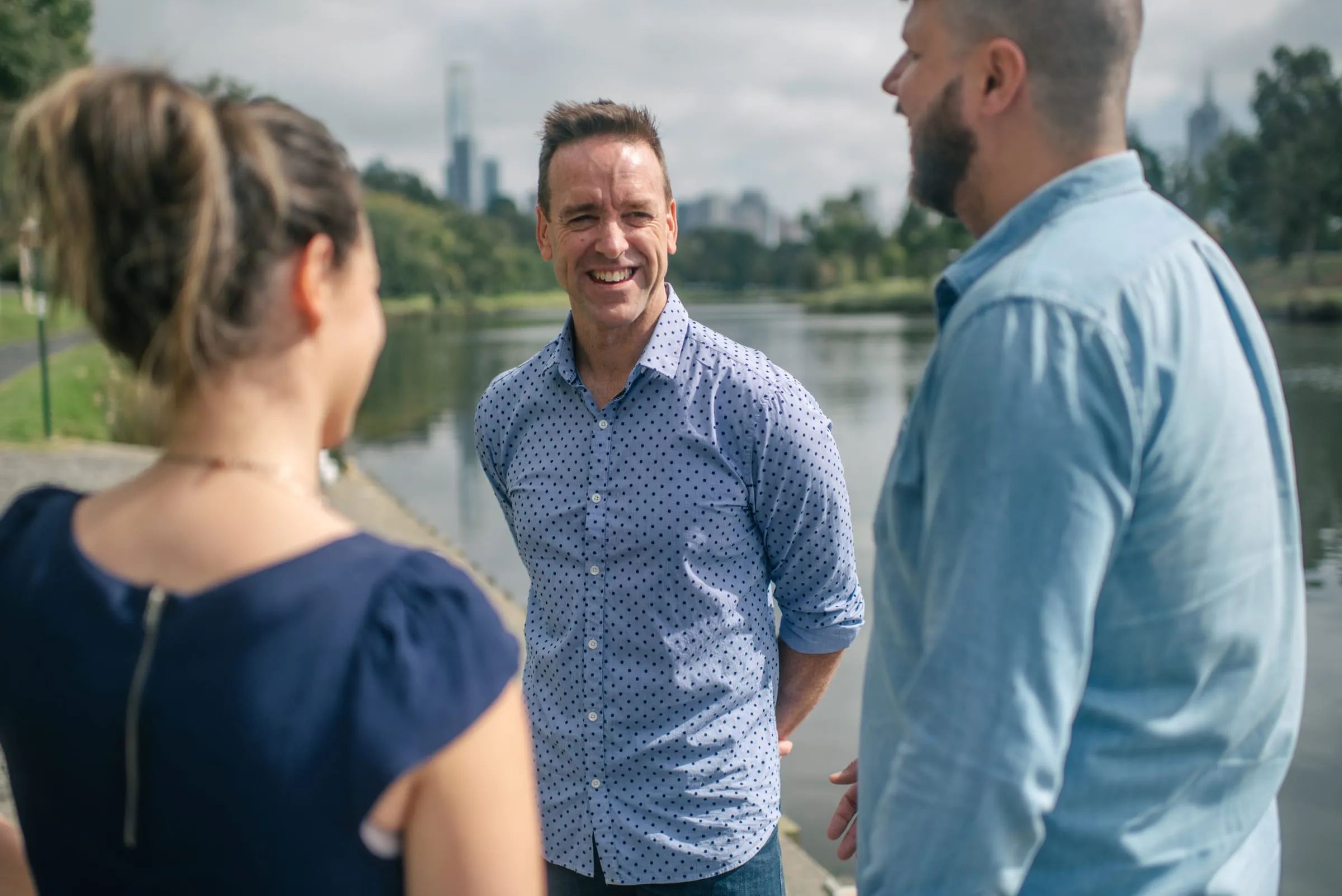 Scott sharing a laugh with two people by the river